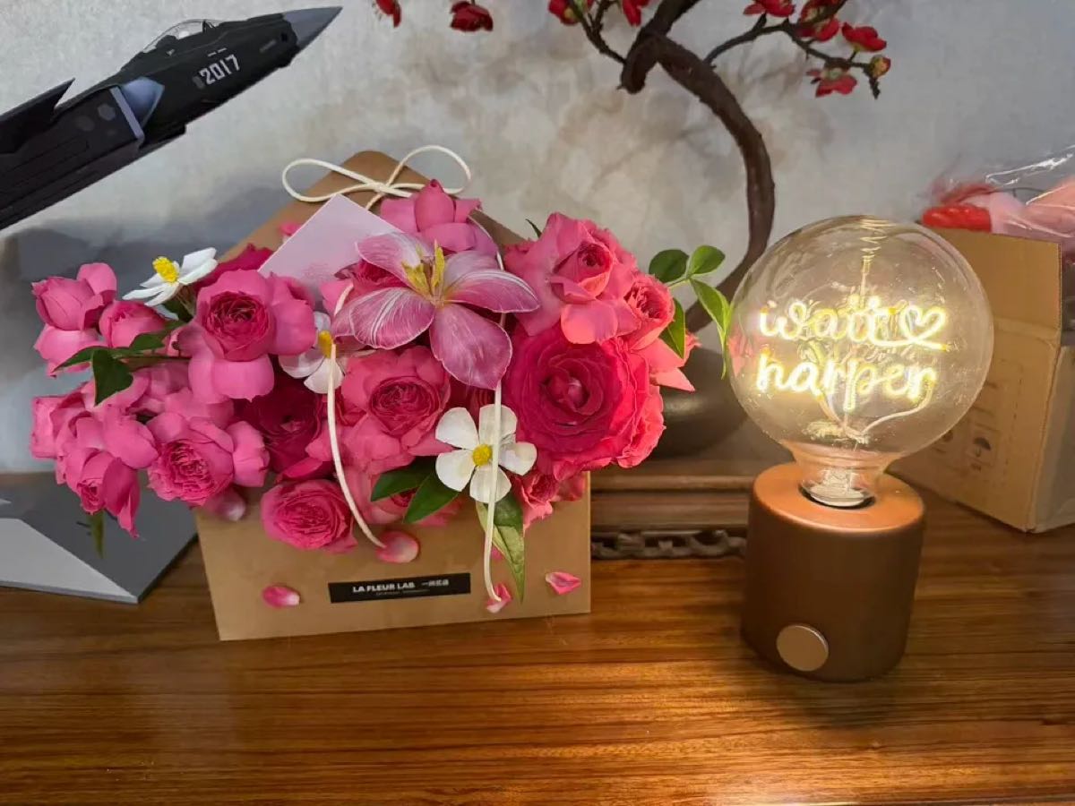 Custom name light bulb lamp beside a pink rose gift box, romantic anniversary gift idea