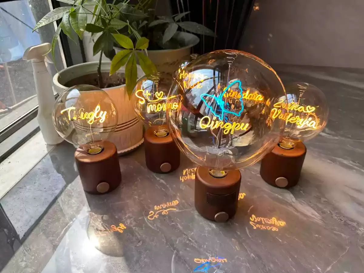 Group of personalized LED filament name lamps with custom lettering on wooden bases